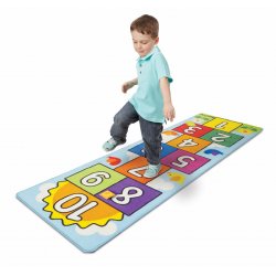 Petit garçon jouant avec le tapis de jeu marelle