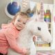 peluche licorne géante et petite fille câline