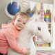 peluche licorne géante et petite fille câline